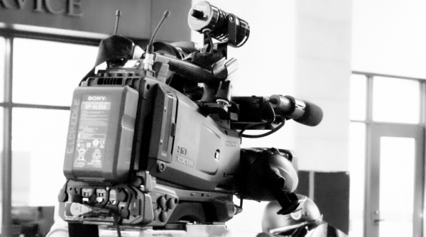 A black and white picture of a camera for a local news media outlet.