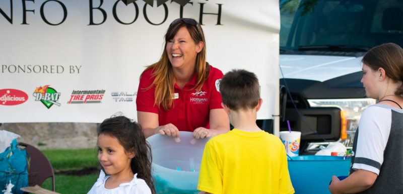 A Herriman employee greets young residents at the information booth at Fort Herriman Towne Days in 2018