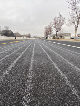 Lines of salt brine stripe a road