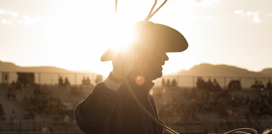 Cowboy spins a rope in the sunset during the 2020 Xtreme Bulls competition