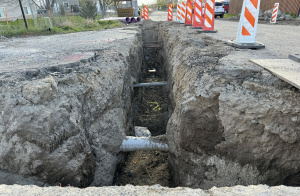 A trench has been dug next to Gina Road and 7300 West, revealing underground utility piping